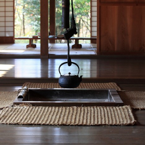 Schmiedeeiserner Teekessel an einer offenen Feuerstelle in einem traditionellen japanischen Haus Schmiedeeiserner Teekessel an einer offenen Feuerstelle in einem traditionellen japanischen Haus